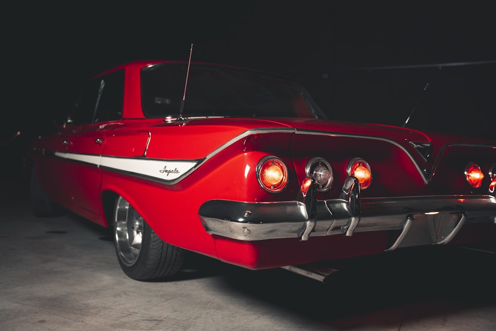 a red classic car parked in a garage