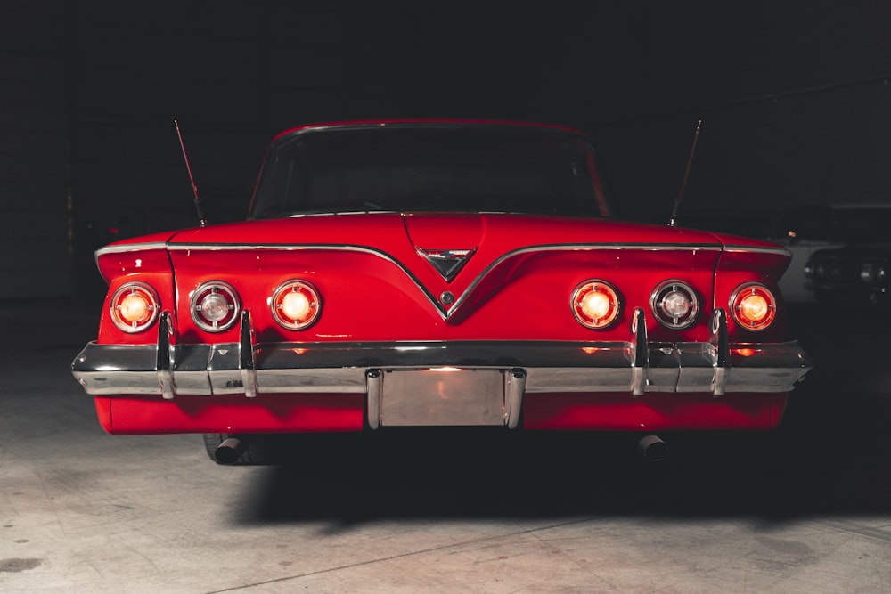 a red classic car parked in a garage