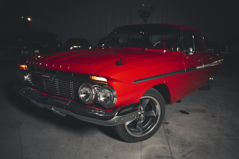 a red classic car parked in a garage