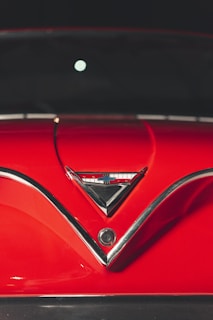Close-up of a vintage racing car hood with chrome details shining under sunlight