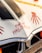 Decorated car hood with 'Happy Halloween' written in red, stylized as if painted with blood. There are also red handprint designs on the white hood, and a part of a pumpkin is visible. A Halloween-themed tape with skulls runs across the top.