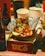 A serving of tacos with various toppings such as diced onions and cilantro, wrapped in aluminum foil, is placed on a table. Surrounding the tacos are beverage bottles and disposable cups. The packaging is colorful with a prominent label reading 'Taco'.
