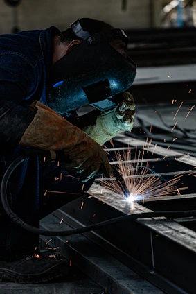 Welder at work creating sparks in an industrial setting