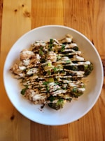 A beautifully plated keto-friendly cauliflower rice bowl with grilled chicken and fresh herbs.