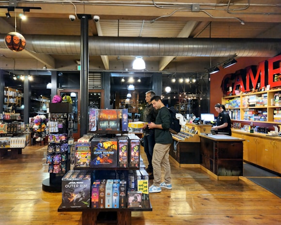 Customers browsing the latest game releases in the cozy Wettzo Market store.