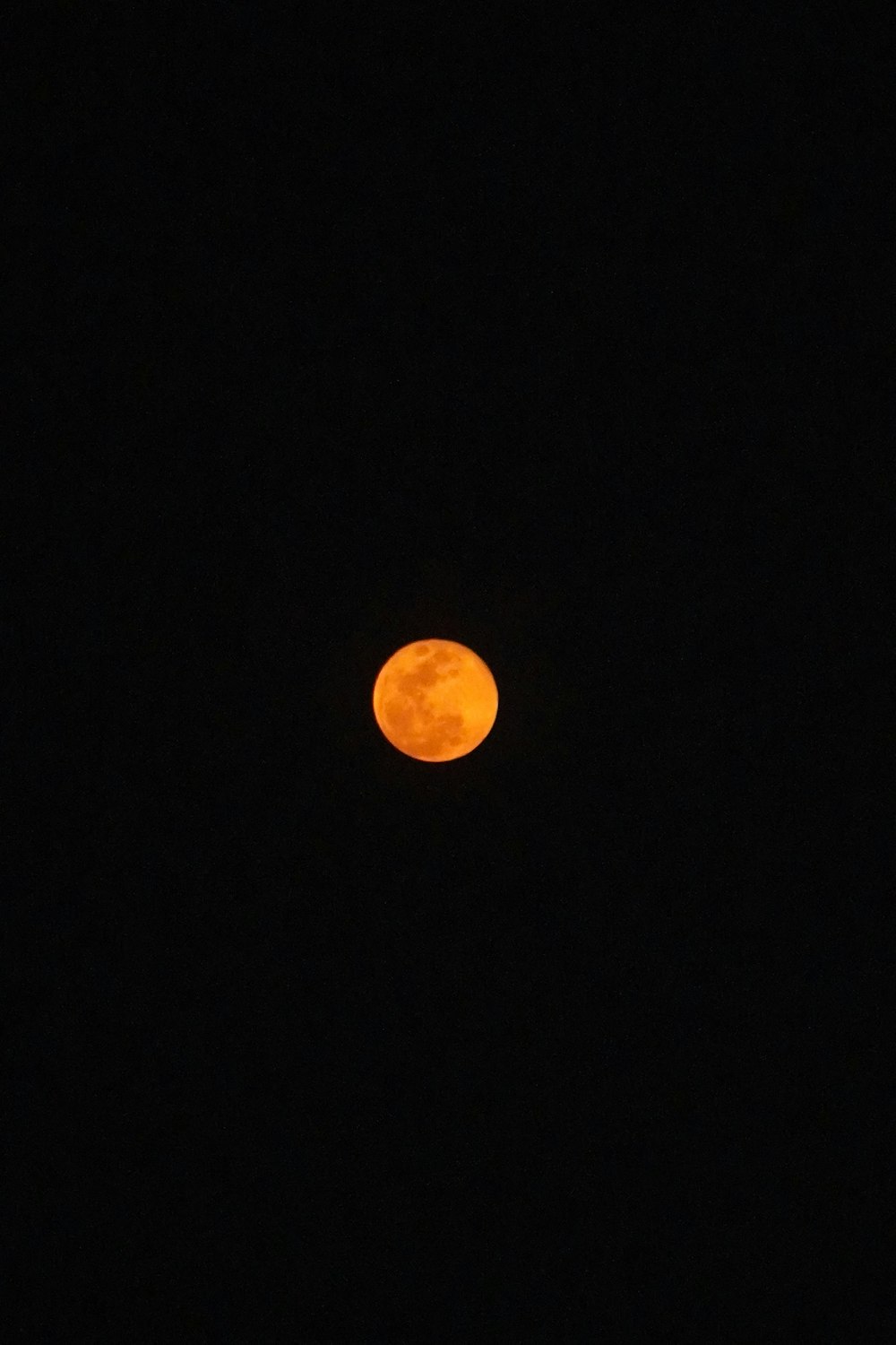 a full moon is seen in the dark sky