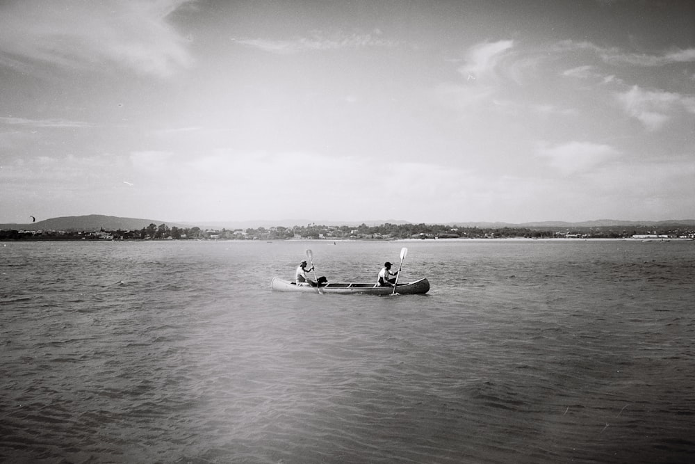 two people in a small boat on the water