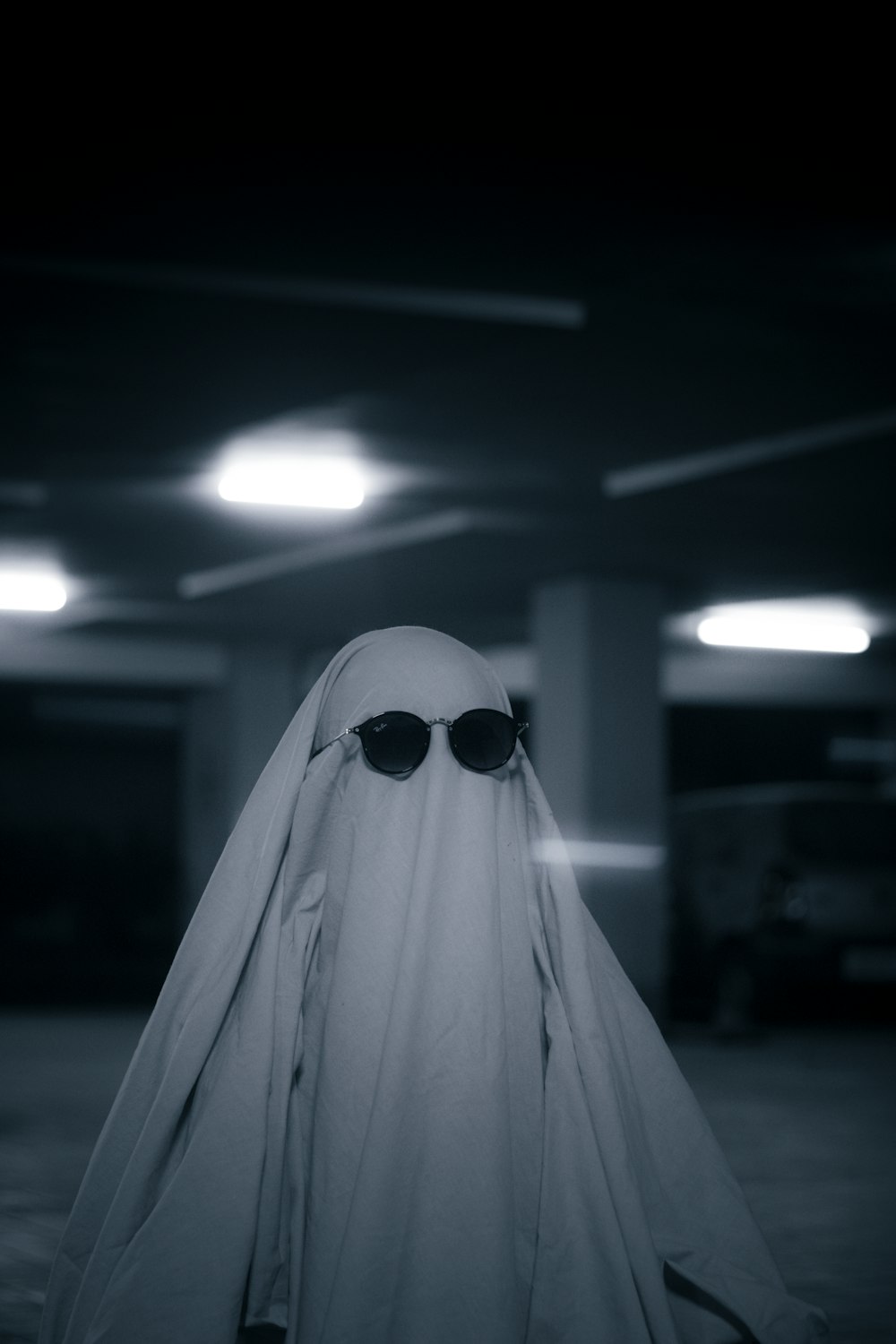 a ghost wearing sunglasses and a white cloak