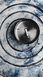 Close-up of a sleek aerospace-grade aluminum portable ashtray with magnetic base inside a car cup holder.