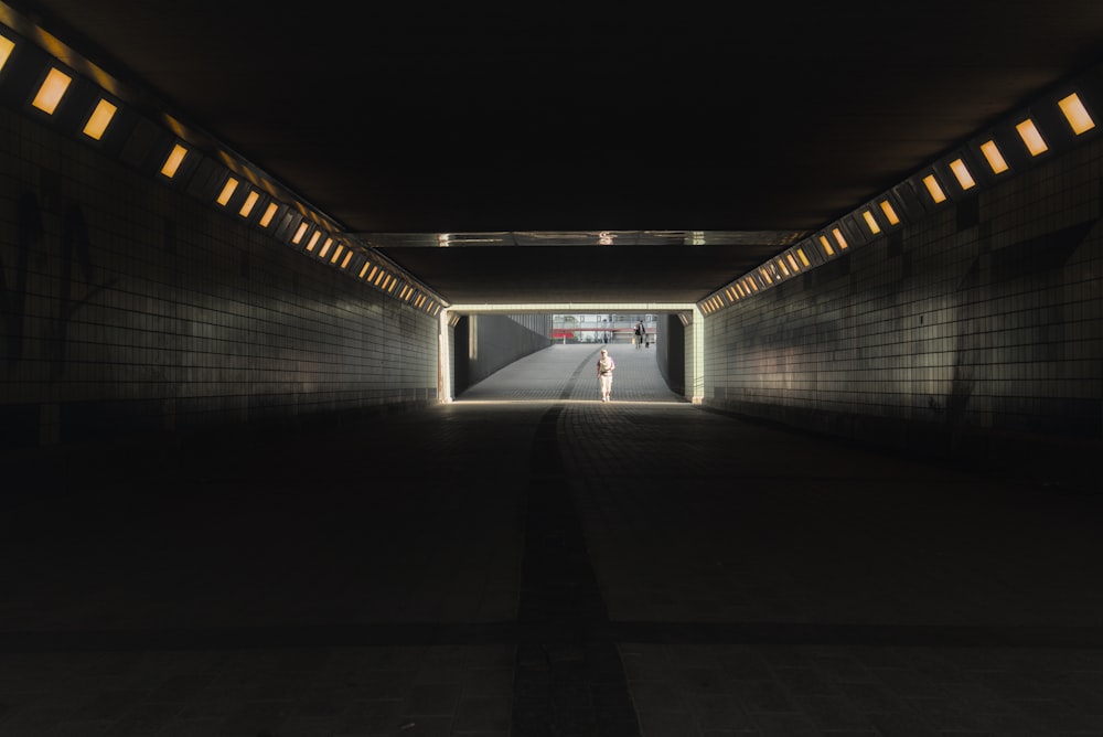 a dark tunnel with a person walking in it