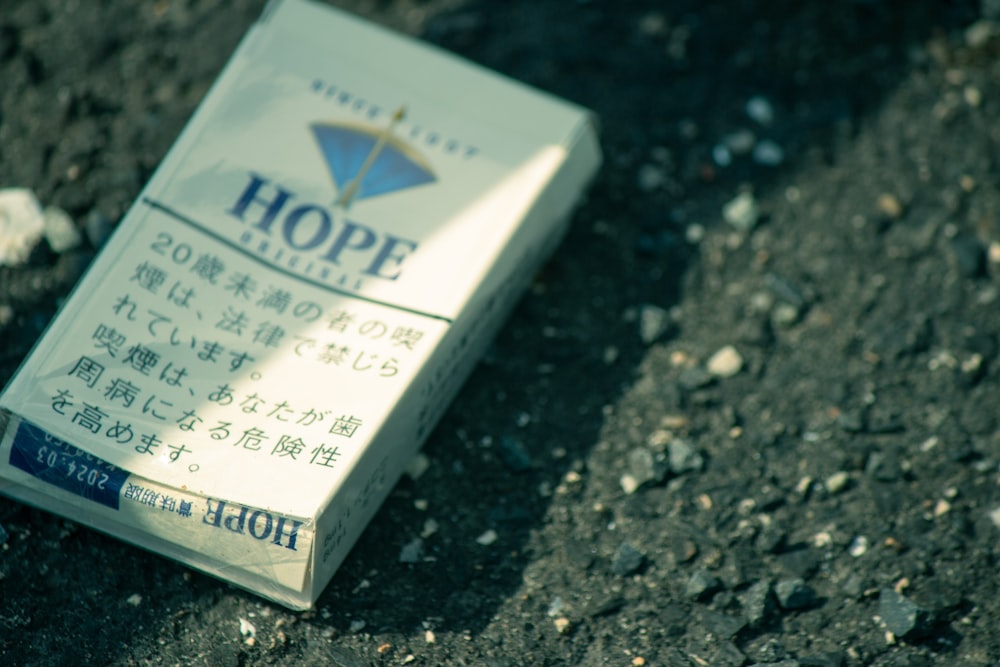 a cigarette box sitting on the ground with writing on it
