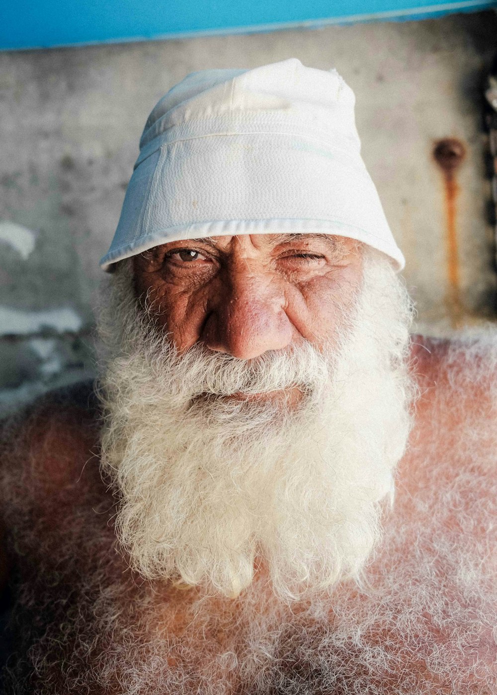 un vecchio con la barba bianca che indossa un cappello bianco