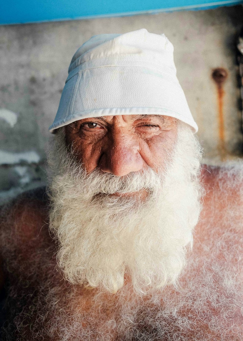 an old man with a white beard wearing a white hat