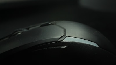 A close-up of a sleek ergonomic computer mouse on a modern desk.