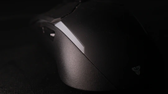 Modern wireless mouse with RGB lighting on a black matte surface
