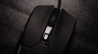 A close-up of a wireless mouse resting on a textured mousepad.