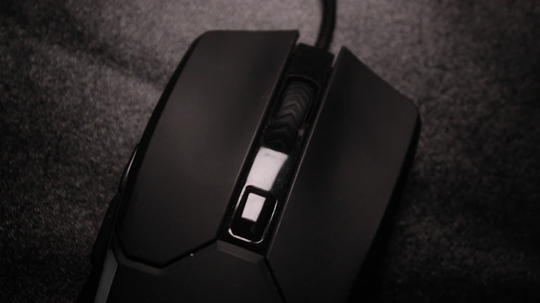 Close-up of a high-tech wireless mouse resting on a textured mousepad.