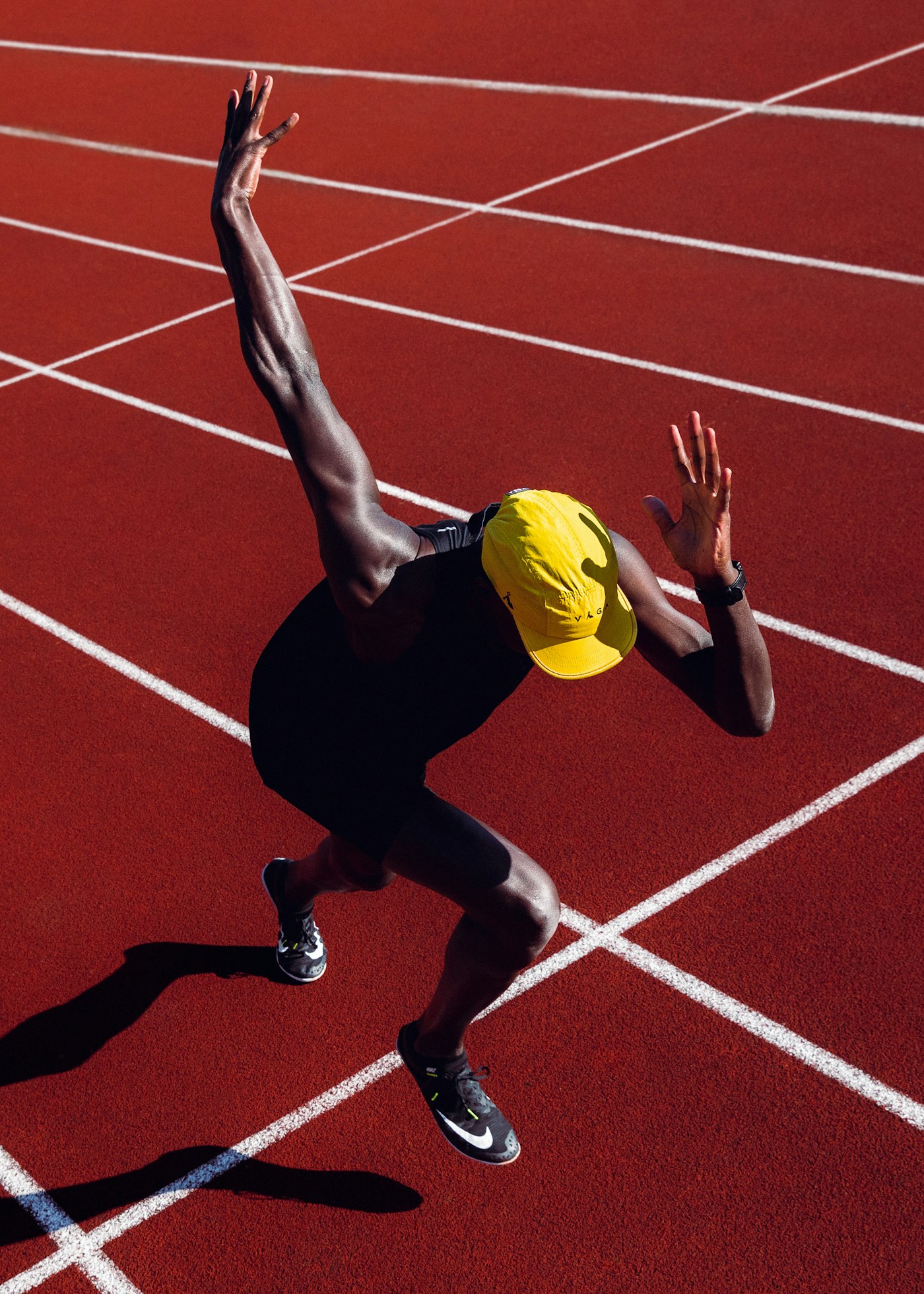 赤い陸上トラックでスタートを切るランナー