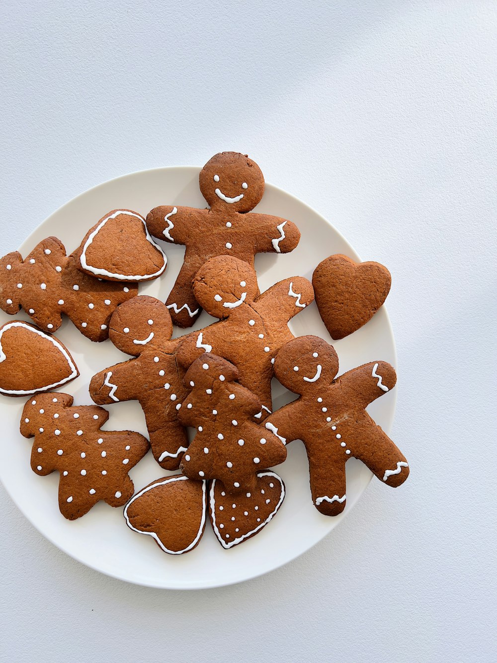 a white plate topped with cut out ginger cookies