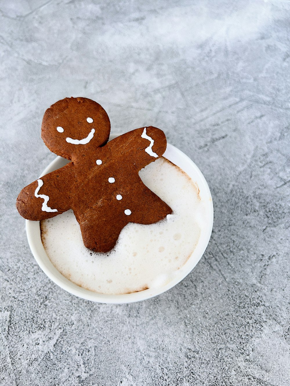 a cup of coffee with a couple of cookies on top of it