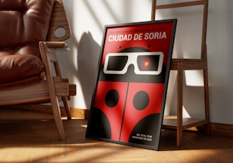 a red ladybug with glasses is sitting in front of a chair