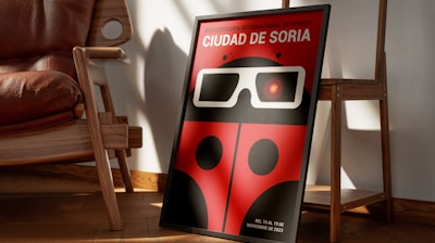 a red ladybug with glasses is sitting in front of a chair