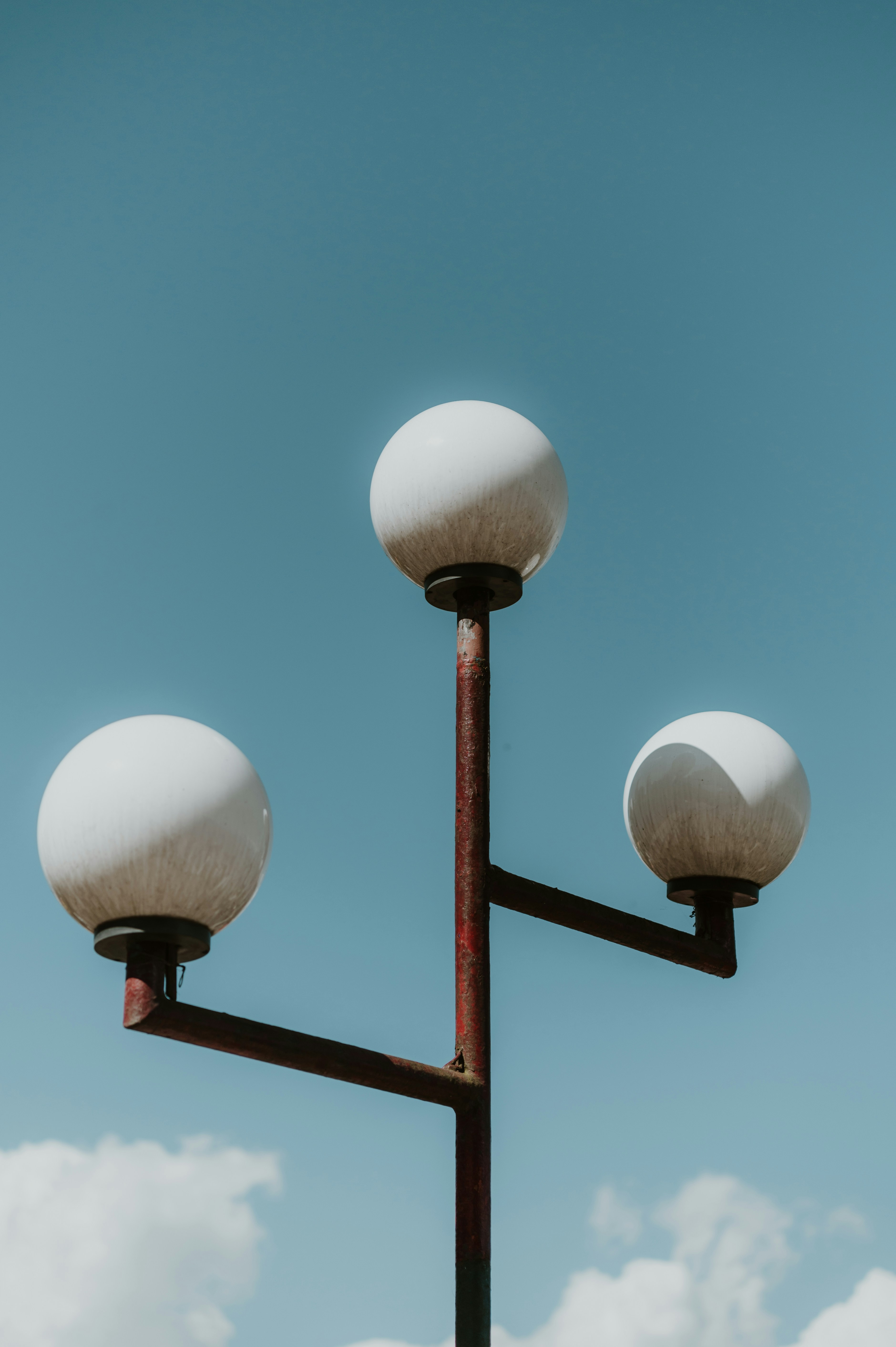 three street lights covered in snow against a blue sky