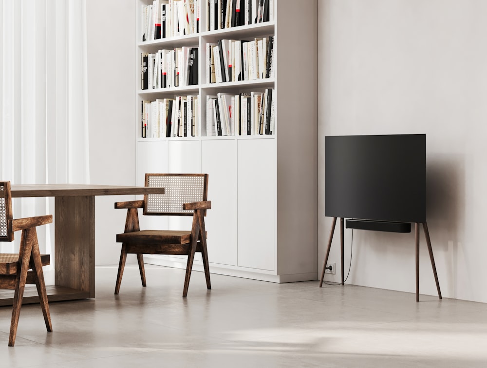 a room with a table, chairs and a television