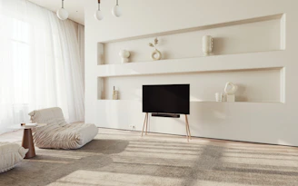 A serene minimalist living room with soft natural light and subtle video art on the walls.
