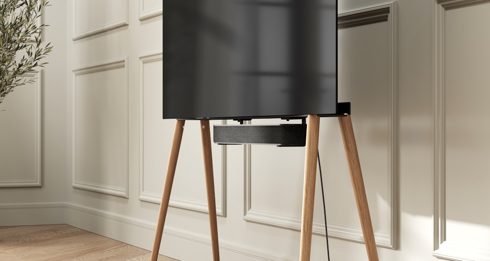 a black speaker sitting on top of a wooden stand