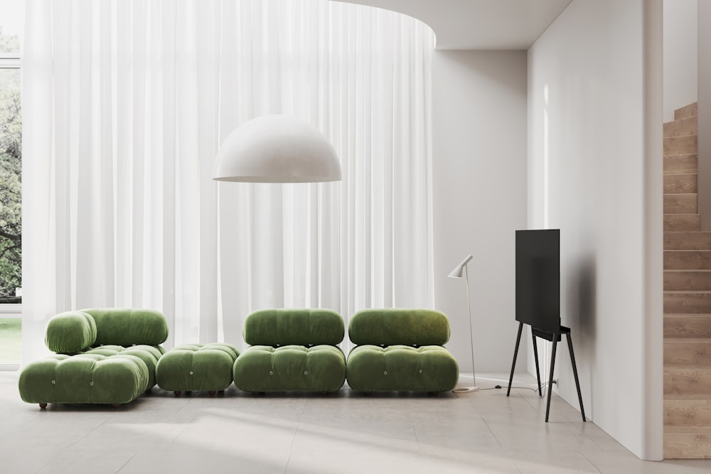 a living room with a green couch and a white lamp