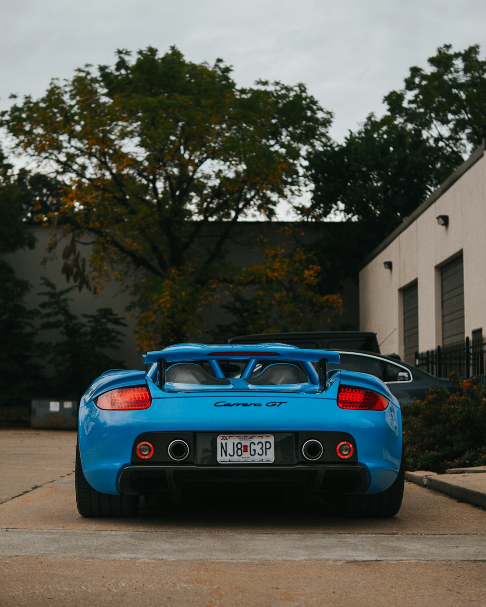 a blue sports car parked in front of a building