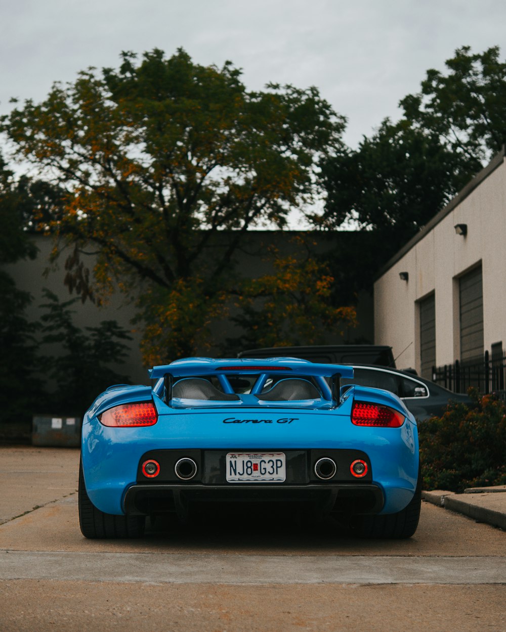 une voiture de sport bleue garée devant un immeuble