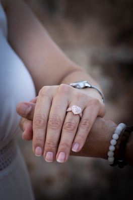 Close-up of a woman’s hand adorned with a sleek gold-plated ring and sterling silver bracelet.