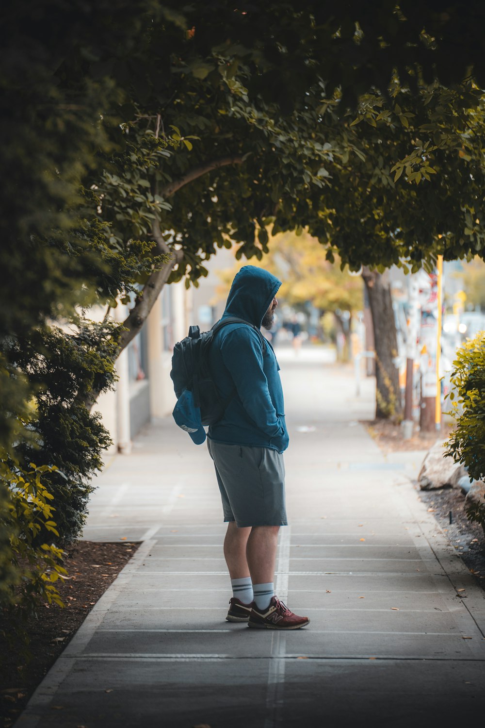 a person with a backpack standing on a sidewalk