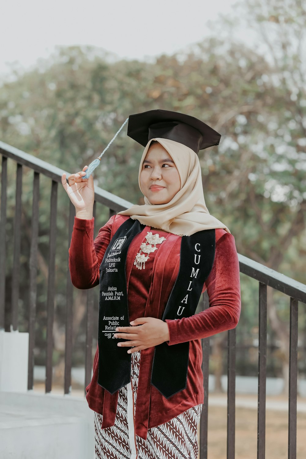 a woman in a graduation gown holding a knife