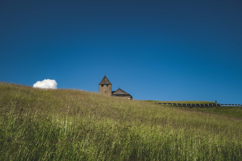 a house on a hill with a fence in the foreground