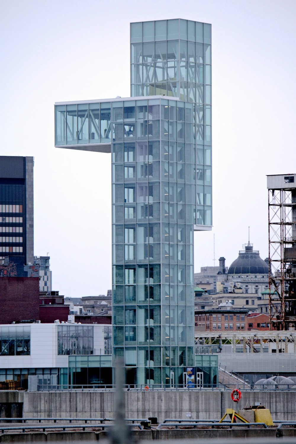 um edifício alto de vidro com um arranha-céu em cima dele