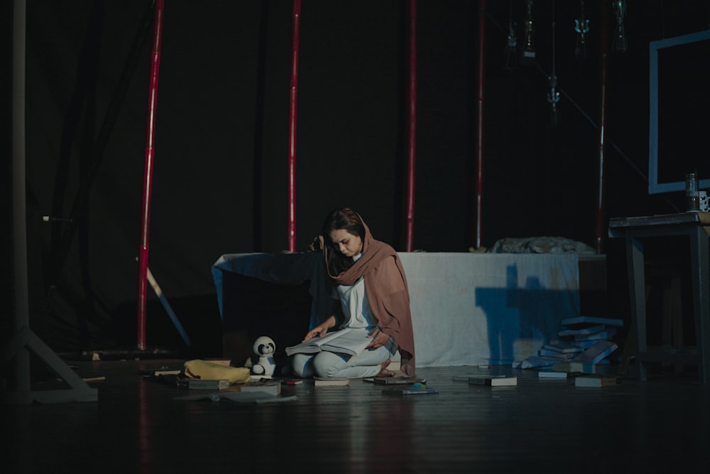 a woman sitting on the floor in front of a laptop