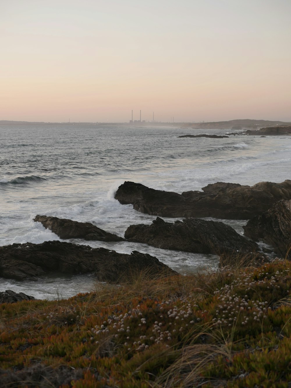 a view of the ocean from a rocky shore