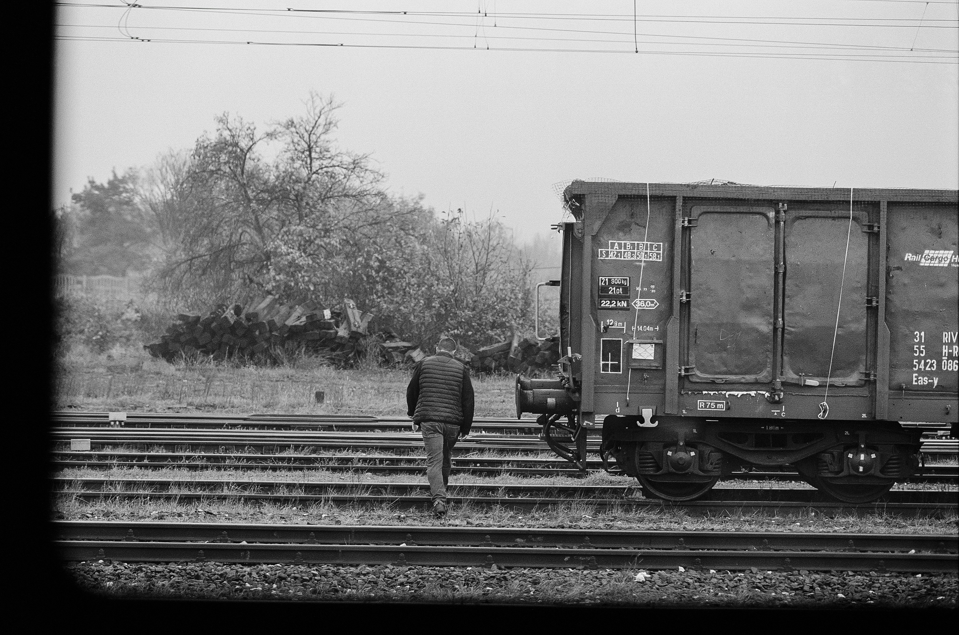 a man standing next to a train on train tracks