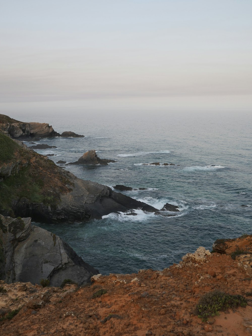 a view of the ocean from a rocky cliff