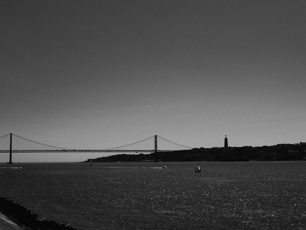 a black and white photo of a bridge and a body of water