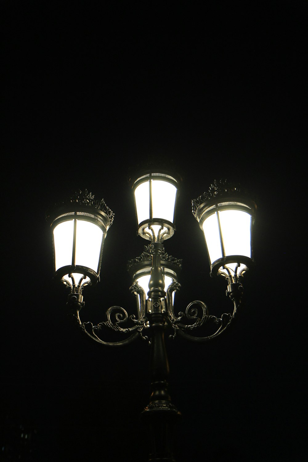 un lampadaire avec trois lumières sur chacun de ses côtés