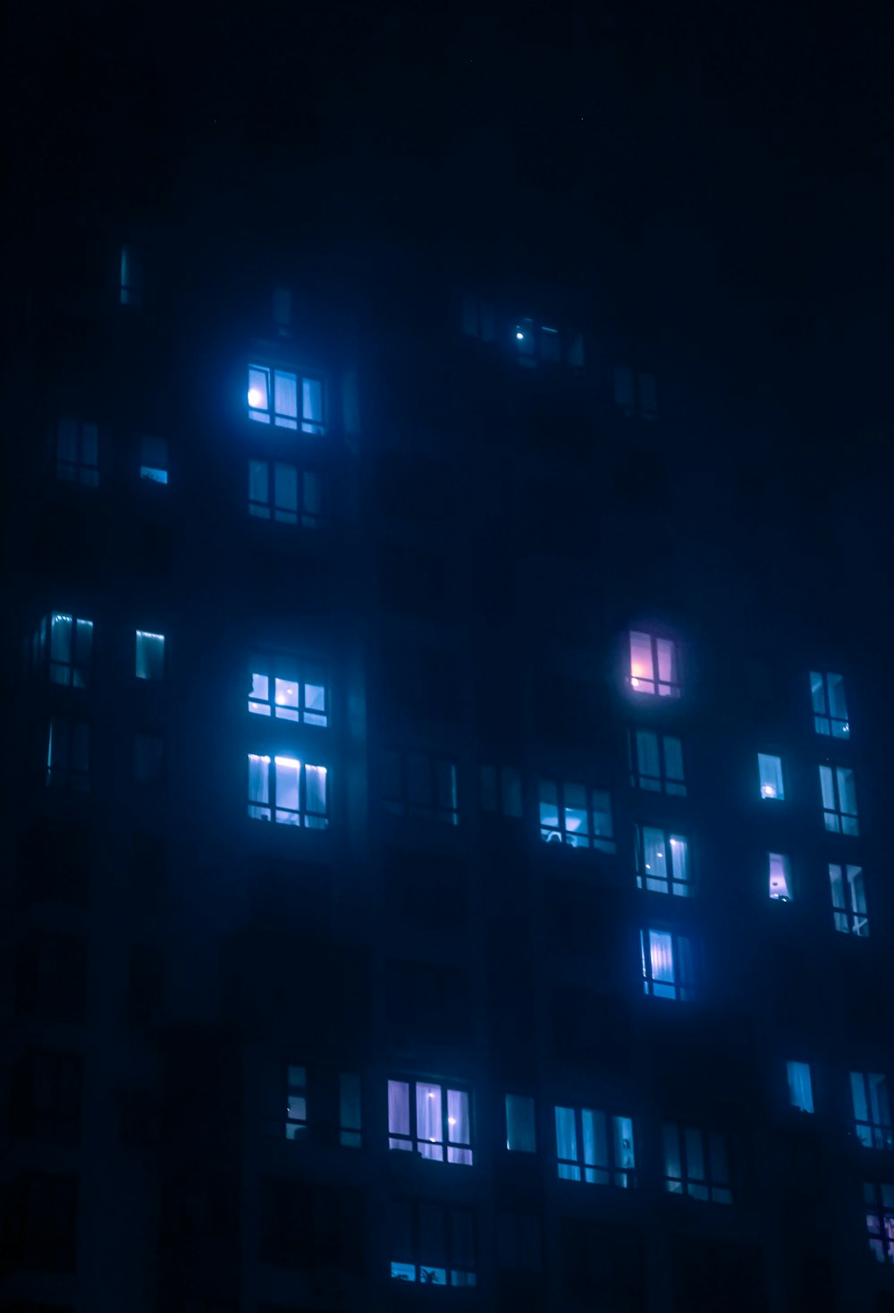 a very tall building with many windows lit up at night