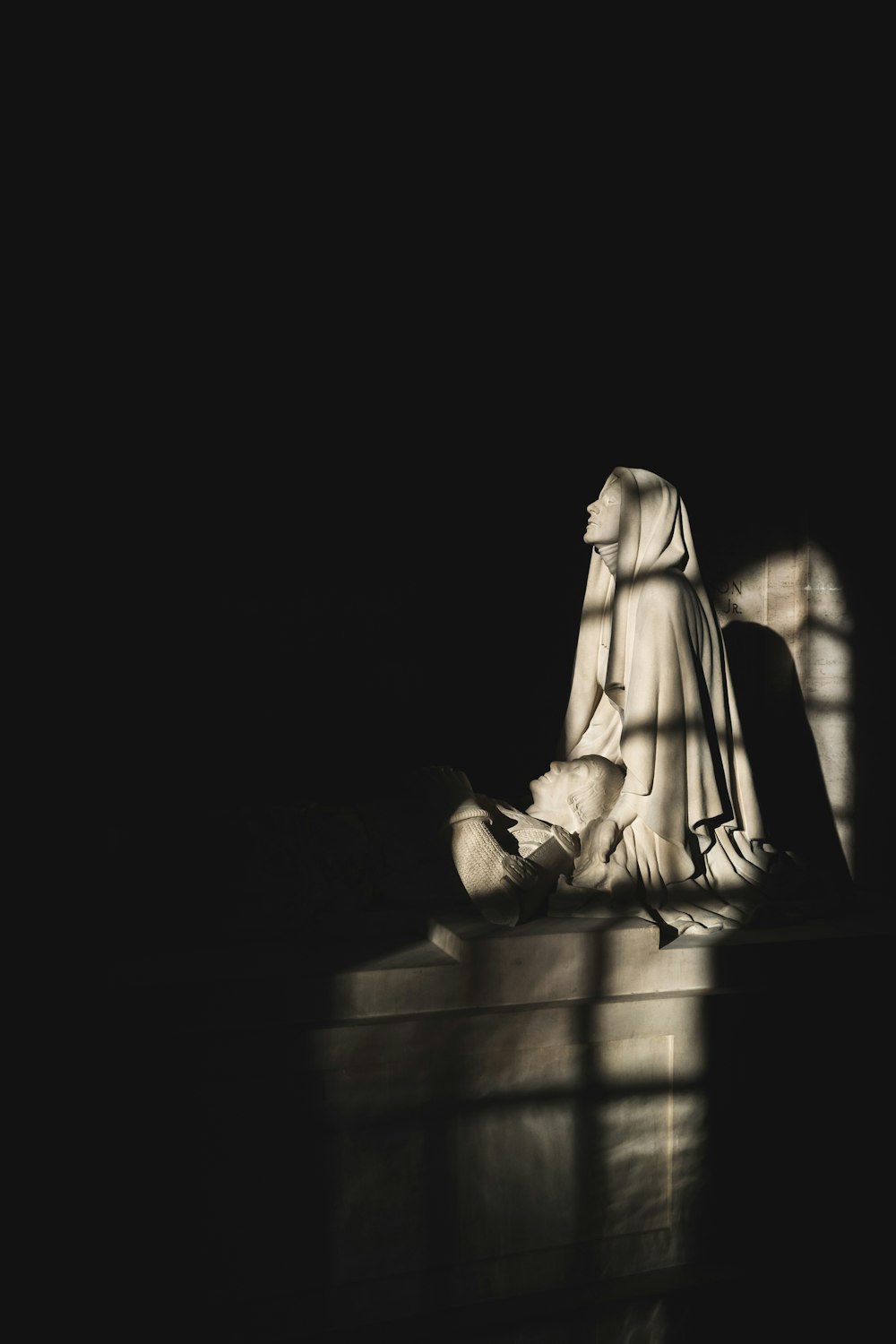 a statue of a woman sitting on the ground