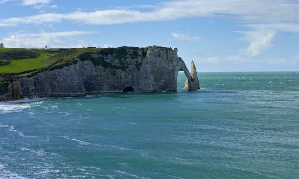 a large rock formation in the middle of a body of water