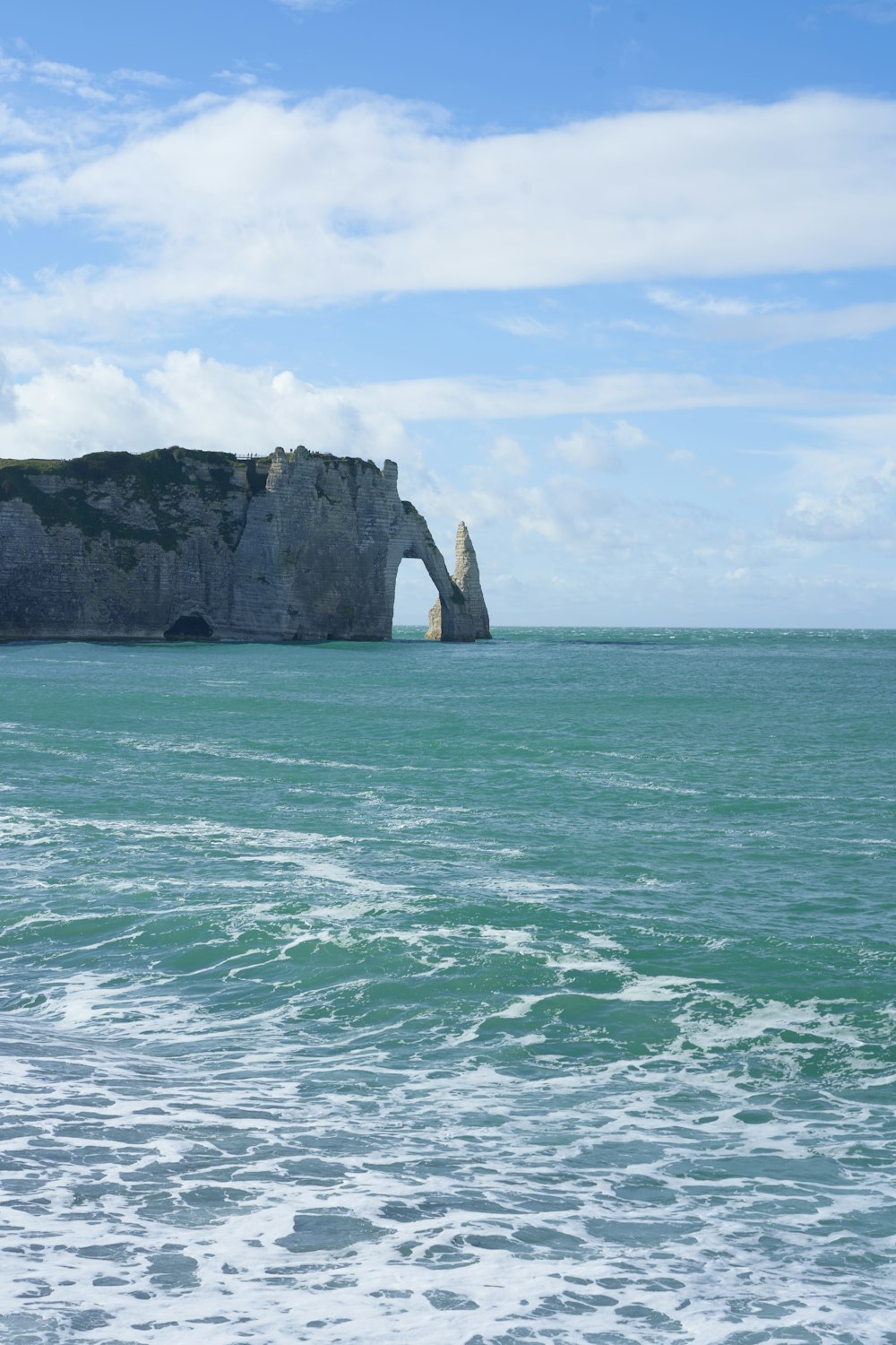 a large rock sticking out of the ocean