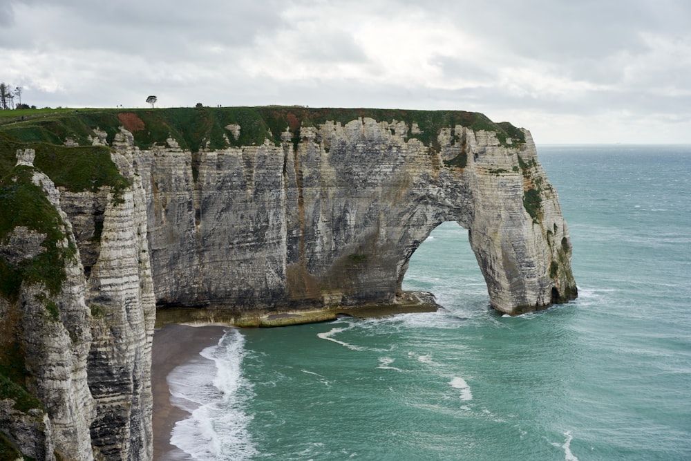 a view of the ocean with a large rock formation in the foreground