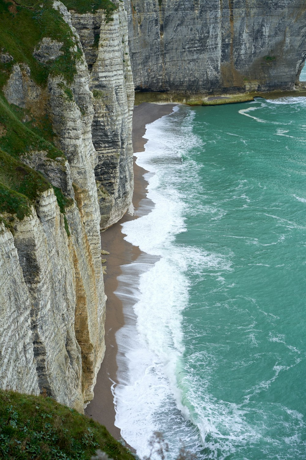a large cliff with a beach next to it